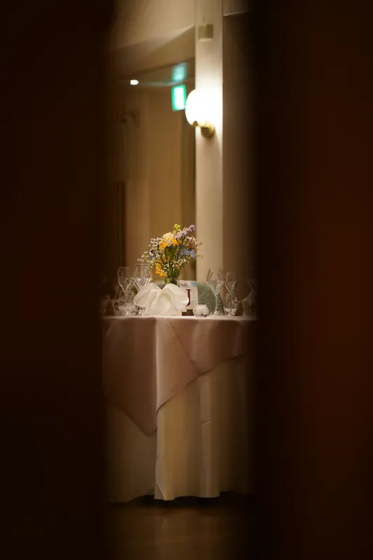 Layered table florals and glassware seen through a doorway