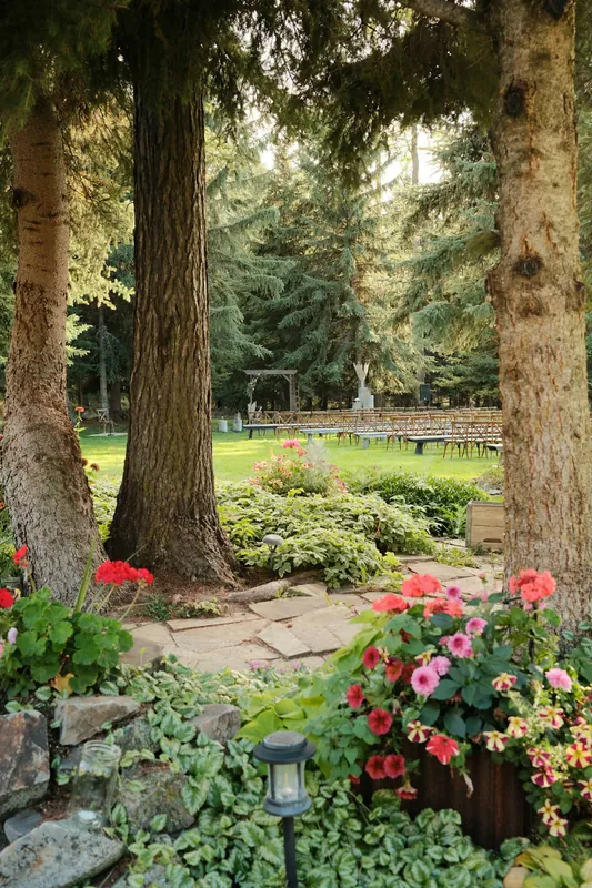 A wooded garden with flower beds and mature trees