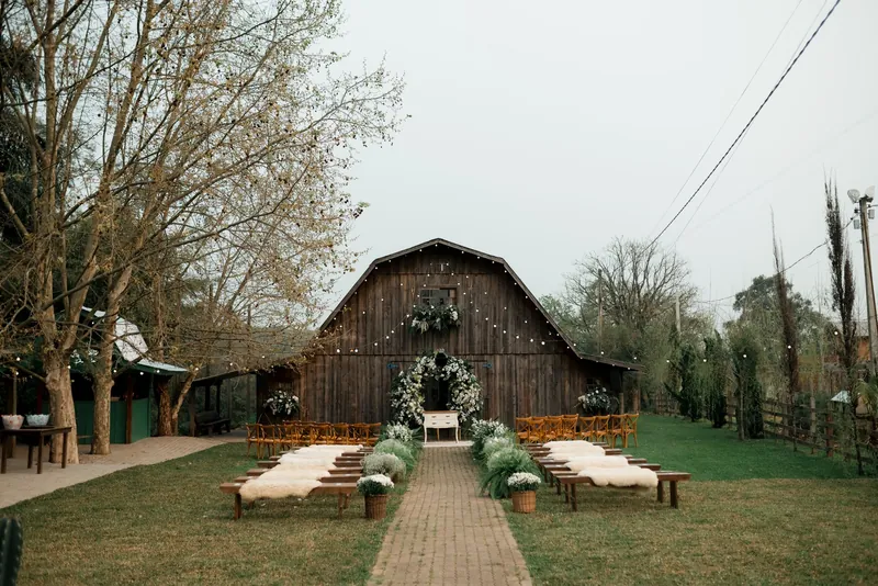 A timber barn, wooden benches and garden ceremony flowers