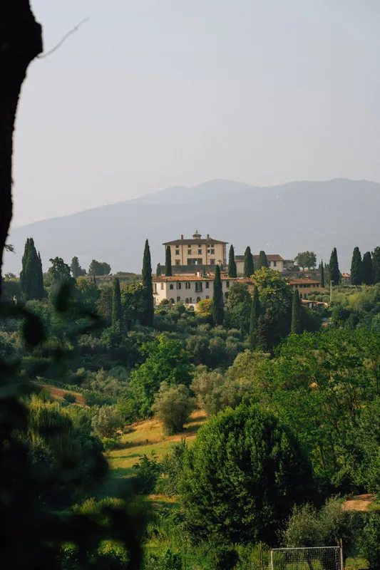 A Tuscan villa surrounded by hills and cypress trees in Italy